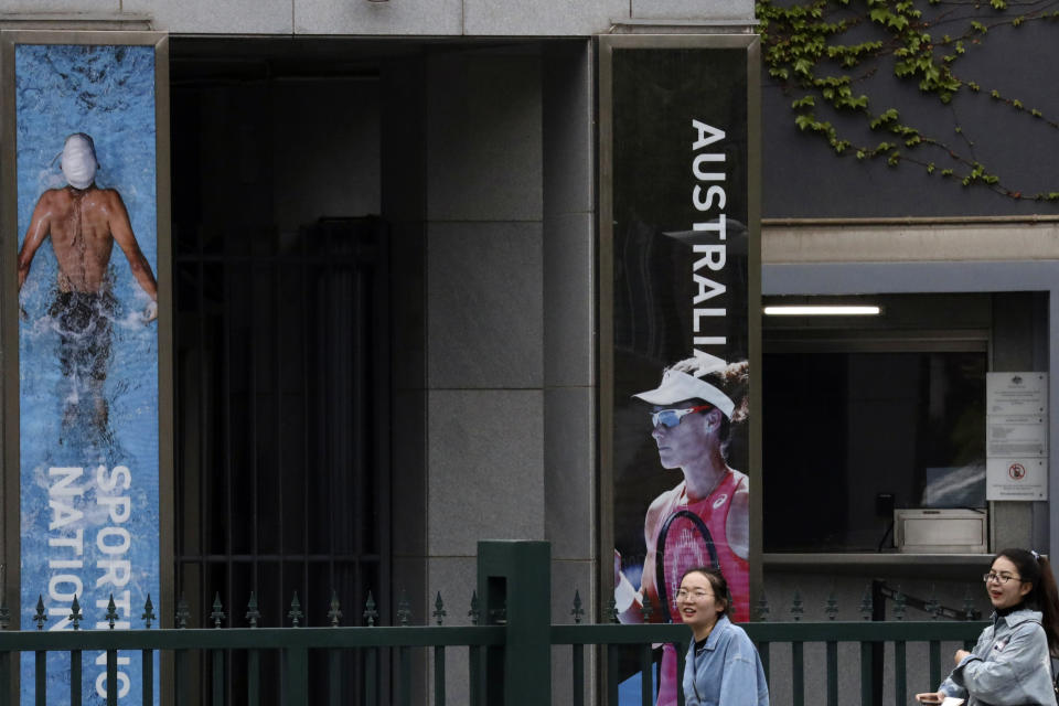 Residents walk past the entrance to the Australian embassy in Beijing, China, Tuesday, April 9, 2019. A security adviser to an Australian prime minister said he warned a Chinese-Australian writer not to travel to China before the blogger and critic of China's Communist Party was detained on arrival at a Chinese airport in January. (AP Photo/Ng Han Guan)