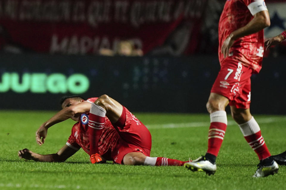 Luciano Sanchez of Argentina's Argentinos Juniors, left, grimaces after snapping his knee during a play with Marcelo of Brazil's Fluminense in a Copa Libertadores round of 16 first leg soccer match at Diego Armando Maradona stadium in Buenos Aires, Argentina, Tuesday, Aug. 1, 2023. (AP Photo/Ivan Fernandez)