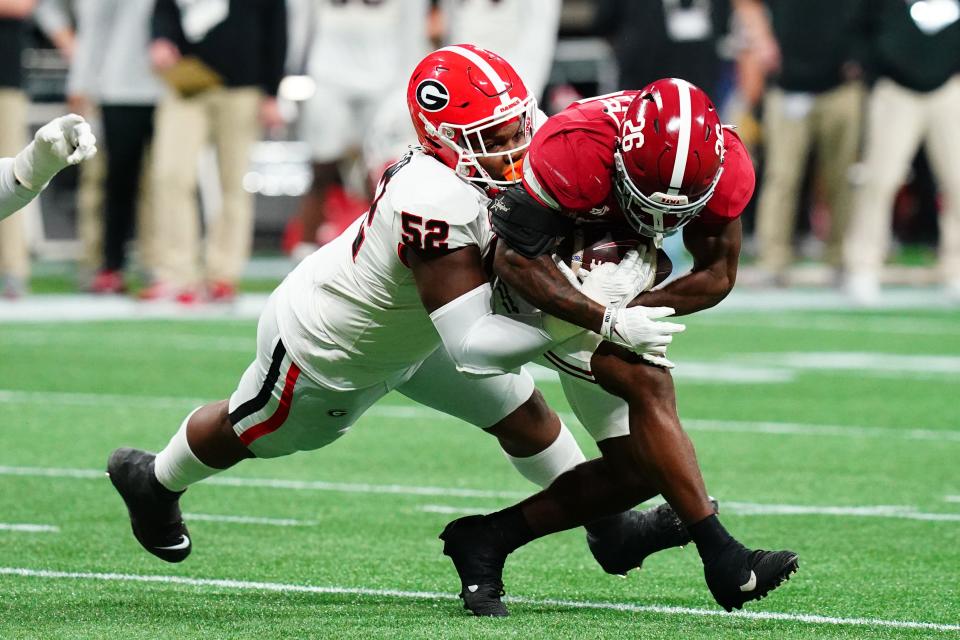 Bulldogs defensive lineman Christen Miller tackles Crimson Tide running back Jam Miller.