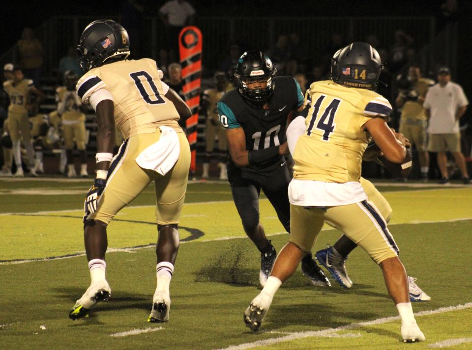 University Christian quarterback Dwayne Stuckey (14) prepares to pass as Providence linebacker Sam Hayward (10) approaches during the teams' 2022 game.