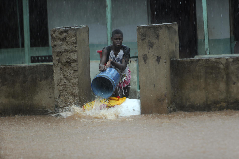 A woman scoops water from her flooded house in Natite neighbourhood, in Pemba city on the northeastern coast of Mozambique, Sunday, April, 28, 2019. Serious flooding began on Sunday in parts of northern Mozambique that were hit by Cyclone Kenneth three days ago, with waters waist-high in areas, after the government urged many people to immediately seek higher ground. Hundreds of thousands of people were at risk. (AP Photo/Tsvangirayi Mukwazhi)