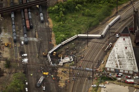 Emergency workers look through the remains of a derailed Amtrak train in Philadelphia, Pennsylvania May 13, 2015. REUTERS/Lucas Jackson