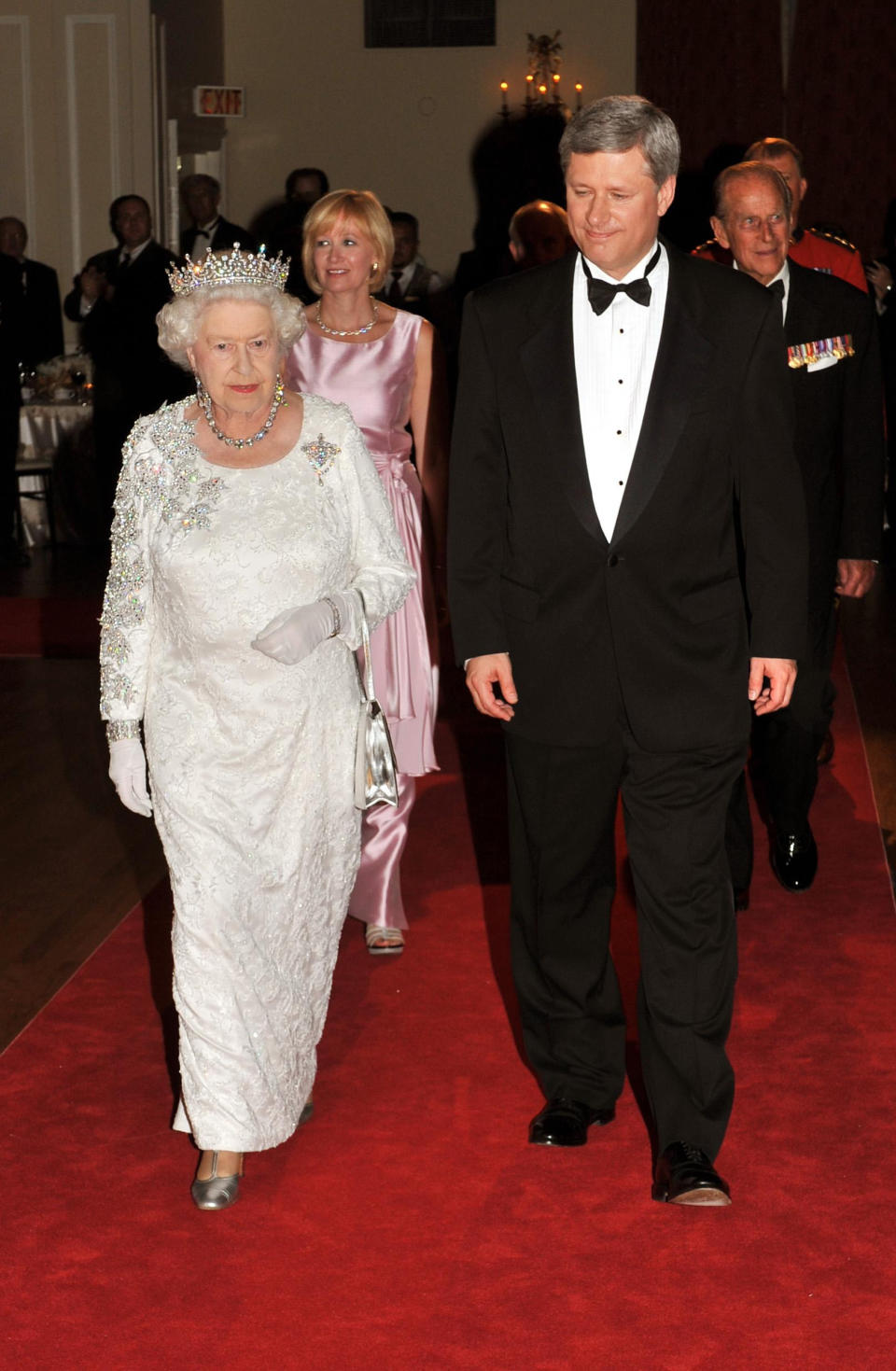 Queen Elizabeth II with former Canadian Prime Minister Stephen Harper walking into the ballroom at the Royal York Hotel in Toronto, where the Canadian government hosted a dinner in her honour. (Photo by John Stillwell/PA Images via Getty Images)