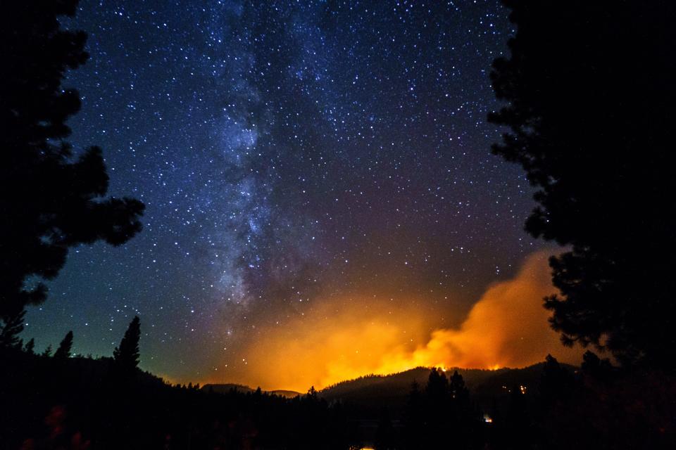 The Milky Way can be seen in the sky as the Dixie Fire burns at a mountain across Highway 89 by Highway 147 near Canyon Dam on Aug. 4, 2021. The Dixie Fire swept through Greenville early in the day and burned down the historic town.