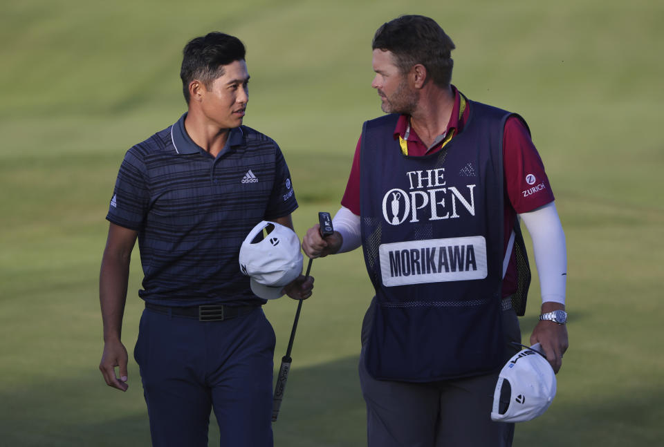 United States' Collin Morikawa, left, walks off the 18th green with his caddie Jonatha Jakovac after he completed his third round at the British Open Golf Championship at Royal St George's golf course Sandwich, England, Saturday, July 17, 2021. (AP Photo/Ian Walton)