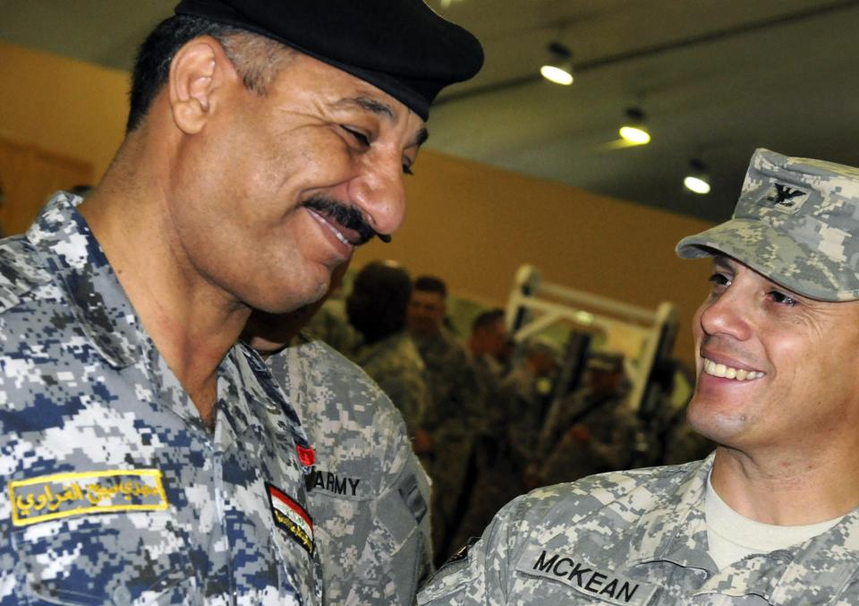 U.S. Army Col. Scott McKean (R), commander, 4th Advise and Assist Brigade, 1st Armored Division, talks with Iraqi police Maj. Gen. Mahdi Gharawi following a transfer of authority ceremony at Contingency Operating Site Marez, in this September 4, 2011 handout provided by U.S. Army. To match Special Report MIDEAST-CRISIS/GHARAWI REUTERS/U.S. Army photo by Spc. Brandon Bednarek/Handout via Reuters (IRAQ - Tags: MILITARY) FOR EDITORIAL USE ONLY. NOT FOR SALE FOR MARKETING OR ADVERTISING CAMPAIGNS. THIS IMAGE HAS BEEN SUPPLIED BY A THIRD PARTY. REUTERS IS UNABLE TO INDEPENDENTLY VERIFY THE AUTHENTICITY, CONTENT, LOCATION OR DATE OF THIS IMAGE. THIS PICTURE WAS PROCESSED BY REUTERS TO ENHANCE QUALITY. AN UNPROCESSED VERSION WILL BE PROVIDED SEPARATELY