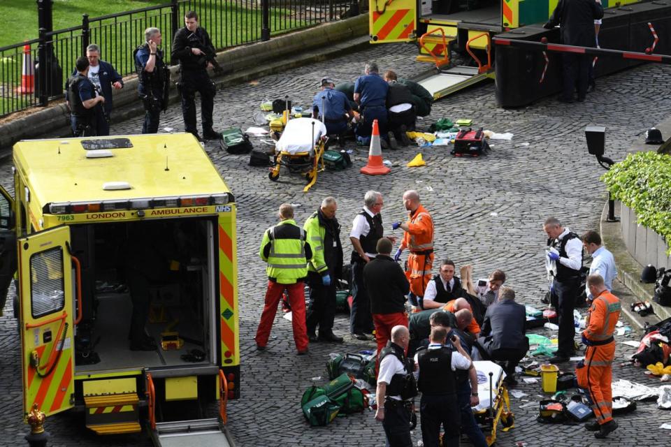 Terror attack: Police and paramedics with an injured man outside the Houses of Parliament (Stefan Rousseau/PA)