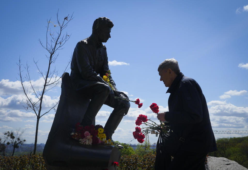 A man lays flowers at an Unknown Soldier Tomb to mark Victory Day in World War II, in Kyiv, Ukraine, Monday, May 9, 2022, as the Russian attack on Ukraine continues. (AP Photo/Efrem Lukatsky)