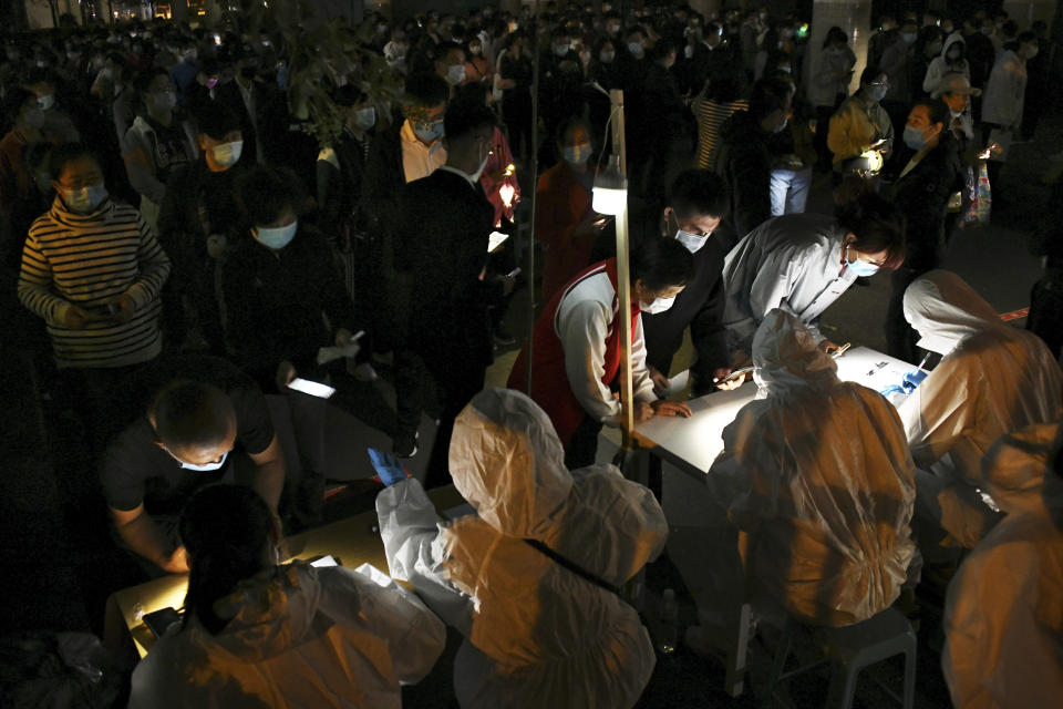 In this photo released by Xinhua News Agency, residents wearing face masks to help curb the spread of the coronavirus line up for the COVID-19 test in Qingdao in east China's Shandong province on Tuesday, Oct. 13, 2020. China says it has carried out more than 4.2 million tests in the northern port city of Qingdao, with no new cases of coronavirus found among the almost 2 million sets of results received. (Li Ziheng/Xinhua via AP)