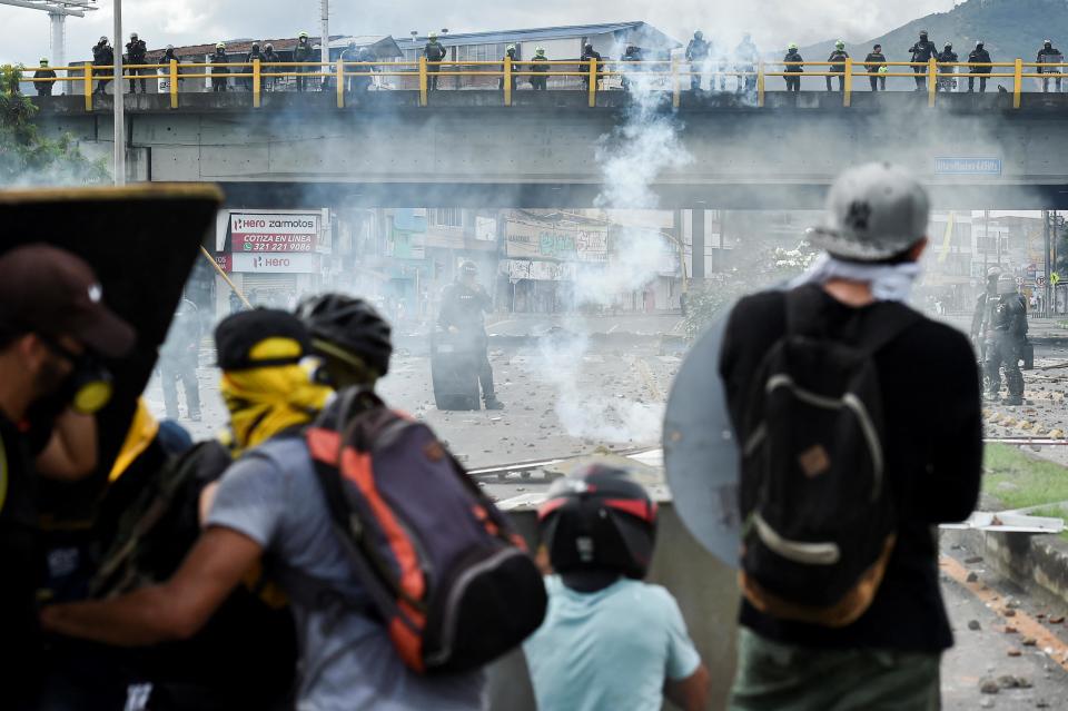 Demonstrators clash with riot police during clashes with riot police during a protest against a proposed government tax reform in Cali, Colombia, on May 3. Faced with the unrest, the government of President Ivan Duque on May 2 ordered the tax reform proposal be withdrawn from Congress, where it was being debated. / Credit: LUIS ROBAYO/AFP via Getty Images