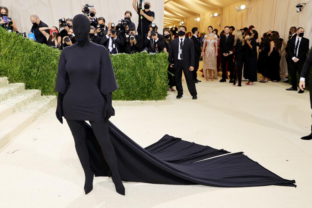 Kim Kardashian West at the 2021 Met Gala covered head to toe in black fabric with a long black train.