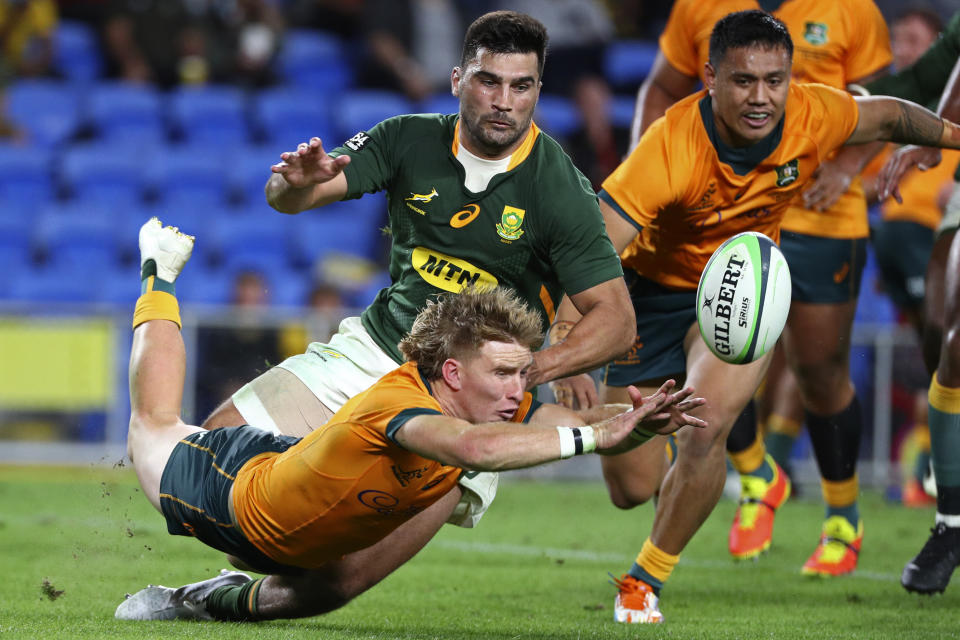 Australia's Tate McDermott, bottom left, and Len Ikitau, right, compete against South Africa's Damian de Allende for a loose ball during their Rugby Championship match on Sunday, Sept. 12, 2021, Gold Coast, Australia. (AP Photo/Tertius Pickard)