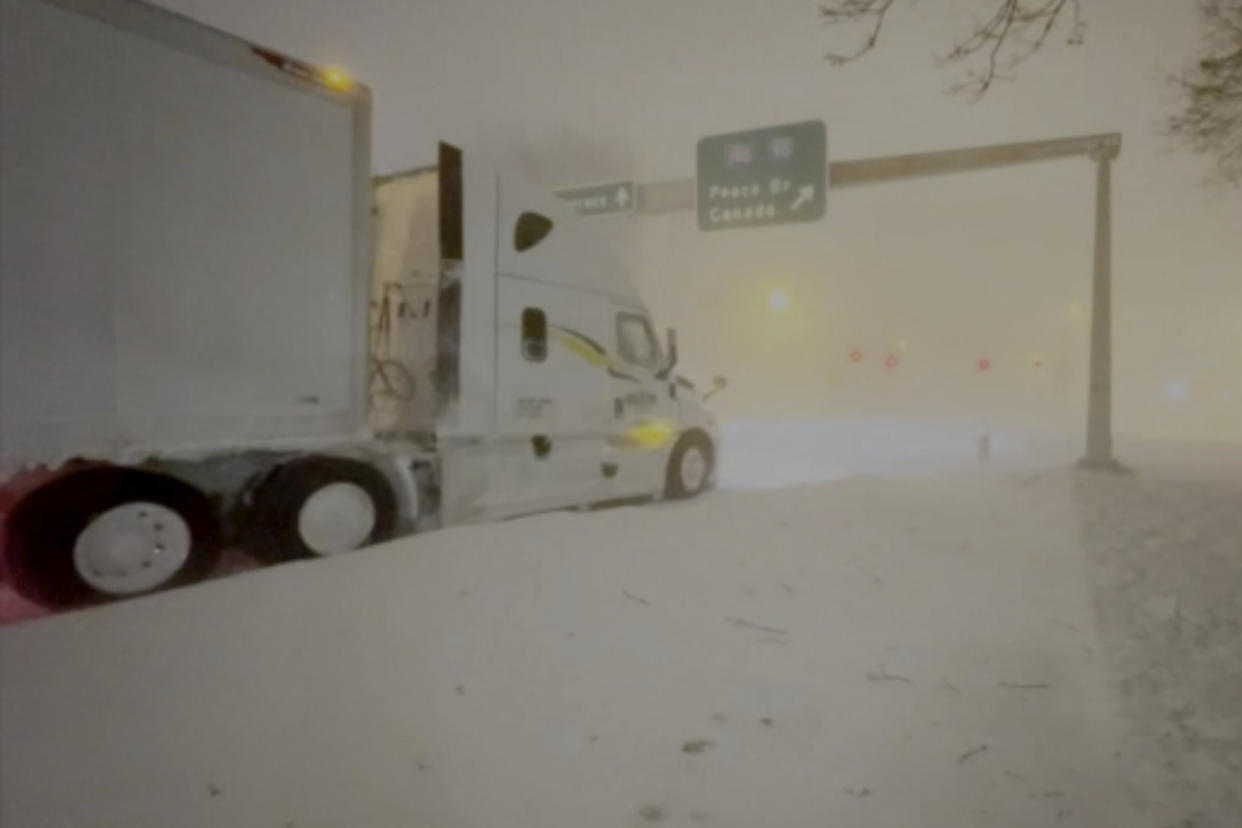 High winds and snow covers the streets and vehicles in Buffalo, N.Y. early Sunday, Dec. 25, 2022. Millions of people hunkered down in a deep freeze overnight and early morning to ride out the frigid storm that has killed at least 20 people across the United States, trapping some residents inside homes with heaping snow drifts and knocking out power to several hundred thousand homes and businesses.(WKBW via AP)