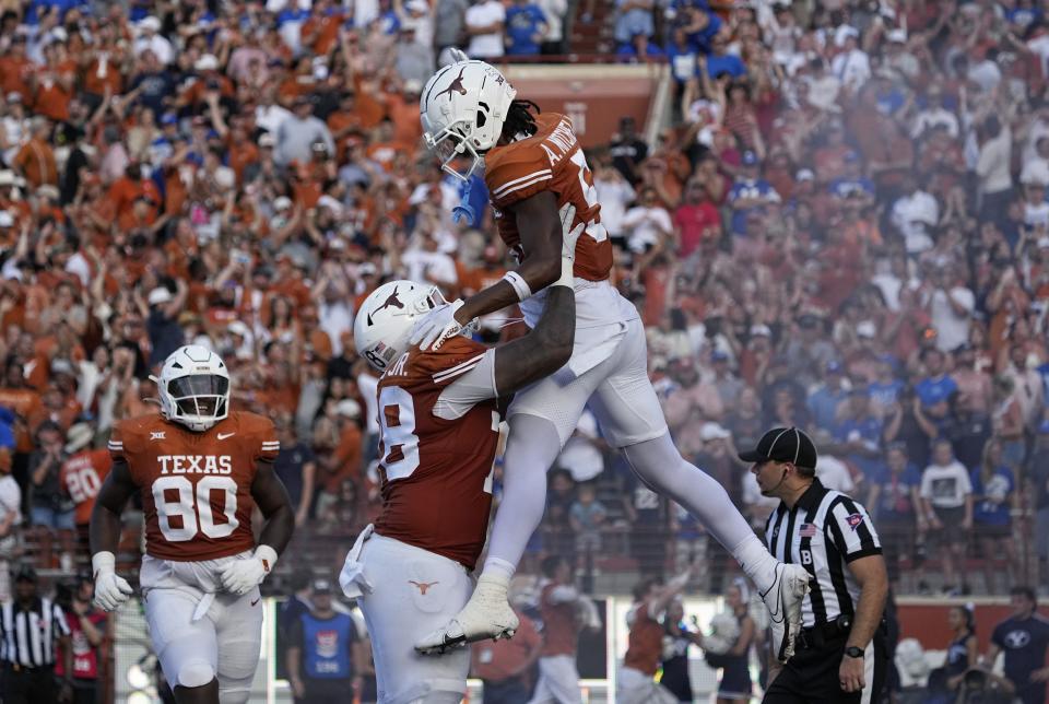 Texas wide receiver Adonai Mitchell (5) is lifted by teammate Texas offensive lineman Kelvin Banks Jr. (78) after he scored a touchdown against BYU during the second half of an NCAA college football game in Austin, Texas, Saturday, Oct. 28, 2023. | Eric Gay, Associated Press