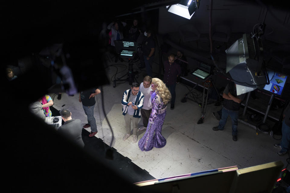 Drag news anchor Amanda, right, talks with producers during the pre-taping of her news program "La Verdrag", on the studio floor of Canal Once, in Mexico City, Wednesday, Oct. 11, 2023. From its inception, the program was meant to radically transform the way LGBTQ+ communities are viewed in Mexican society. (AP Photo/Aurea Del Rosario)