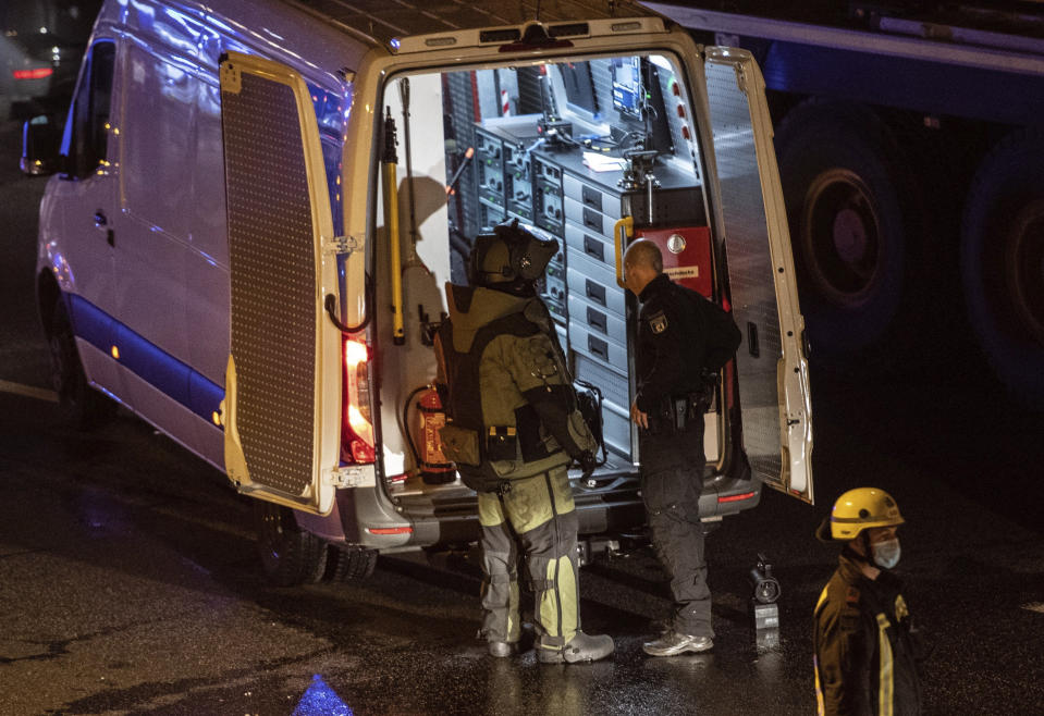 Police officers and fire fighters work on the scene following several accidents on the city motorway A100 in Berlin, Germany, Tuesday, Aug. 18, 2020. According to German news agency dpa, prosecutors say the series of crashes caused by a 30-year-old Iraqi man on the highway was an Islamic extremist attack. (Paul Zinken/dpa via AP)