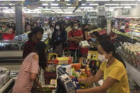 People line up to buy food and other supplies at a 24-hour supermarket in Yangon, Myanmar, Tuesday, March 24, 2020, following the first cases of coronavirus announcement. Myanmar has announced its first two confirmed cases of COVID-19, one in the nation's biggest city, Yangon, and the other in the western state of Chin. For most people, the new coronavirus causes only mild or moderate symptoms. For some it can cause more severe illness. (AP Photo/Thein Zaw)