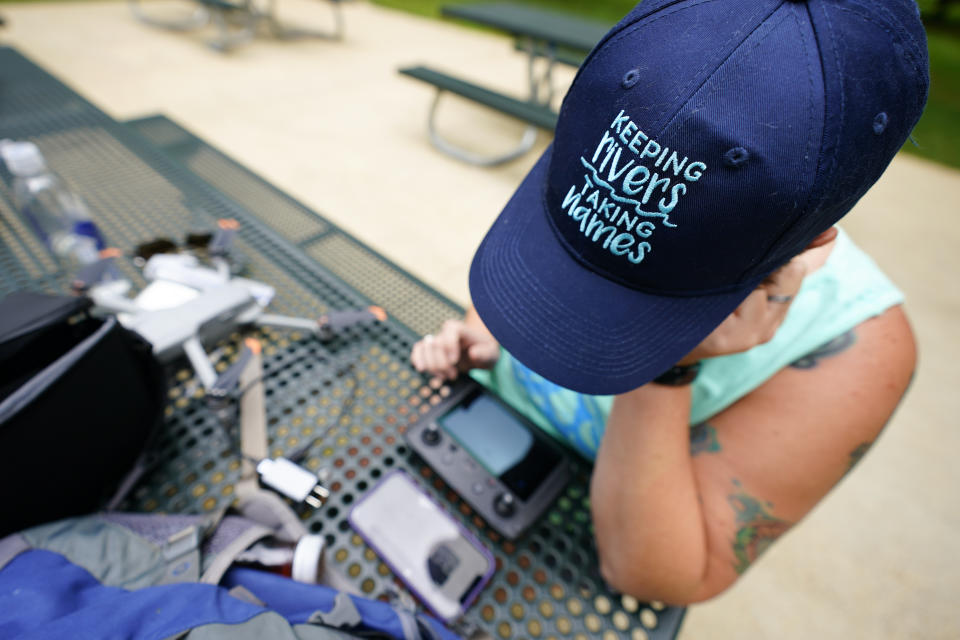 Cara Schildtknecht, the Waccamaw Riverkeeper with Winyah Rivers Alliance, sets up her drone's remote control before taking her first-ever drone flight during training near Riley's Lock along the Potomac River, Tuesday, June 7, 2022, in Poolesville, Md. Schildtknecht said a drone will help her see areas in her watershed that are hard to reach by boat, record floods and find polluters. (AP Photo/Julio Cortez)