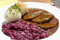 <p>Fast ebenso beliebt ist der Sauerbraten. Wer das Gericht auf traditionelle Weise selbst zubereiten möchte, muss das Fleisch für einige Tage in einer Marinade aus Essig, Wasser oder Wein, Zwiebeln, Karotten und Gewürzen wie Lorbeer, Gewürznelke und Pfefferkörnern einlegen. Viele Deutsche mögen dazu Kartoffelklöße. (Bild: Getty Images) </p>