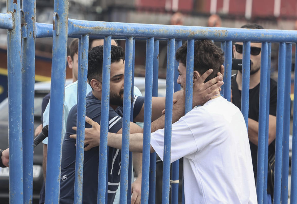 Syrian survivor Fedi, 18, right, one of 104 people who were rescued from the Aegean Sea after their fishing boat crammed with migrants sank, reacts as he reunites with his brother Mohammad, who came from Italy to meet him, at the port of Kalamata, Greece, Friday, June 16, 2023. The round-the-clock effort continued off the coast of southern Greece despite little hope of finding survivors or bodies after none have been found since Wednesday, when 78 bodies were recovered and 104 people were rescued. (John Liakos/InTime News via AP)