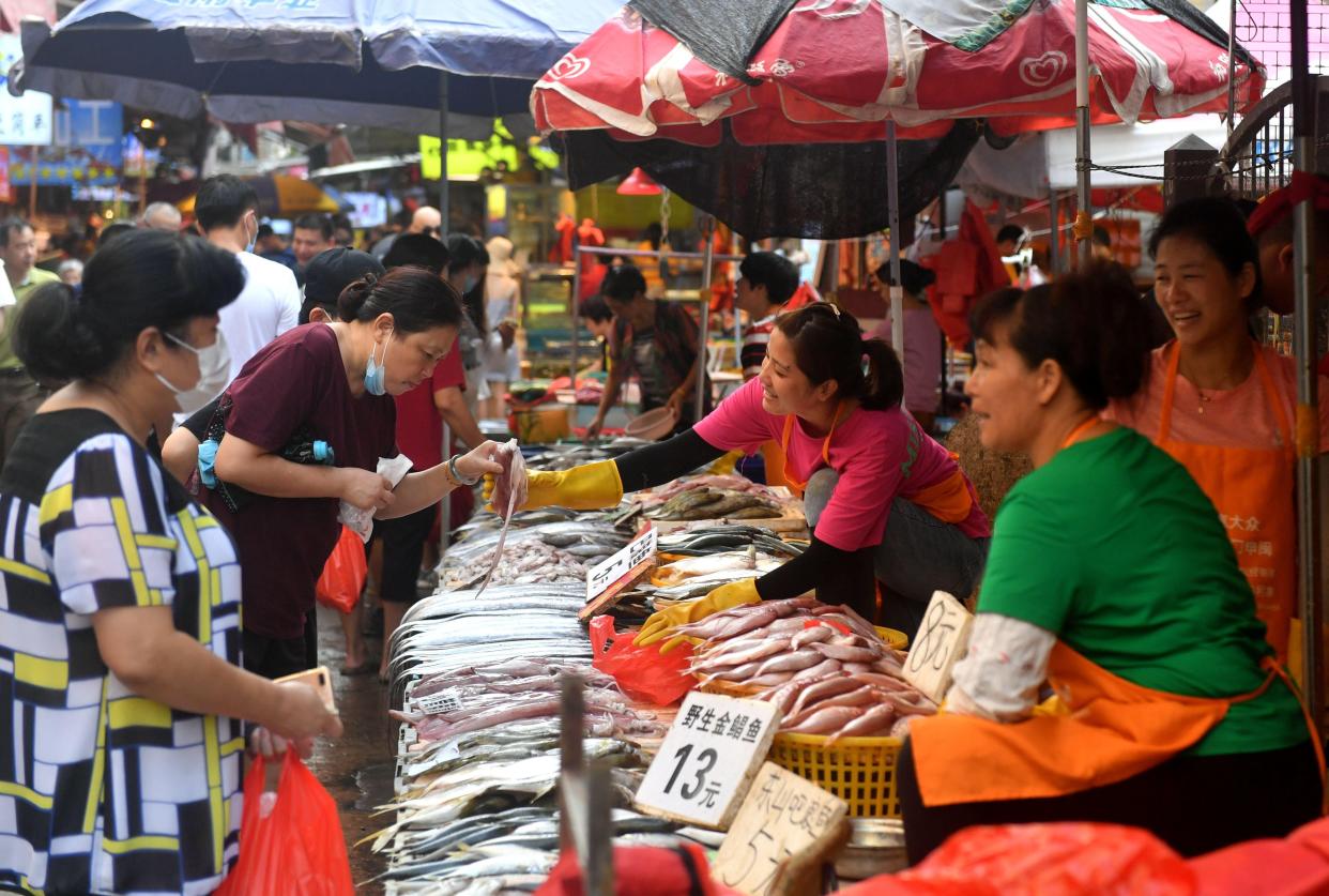 People shop for fish at a seafood market in the old district on August 28, 2020 in Xiamen, Fujian Province of China.