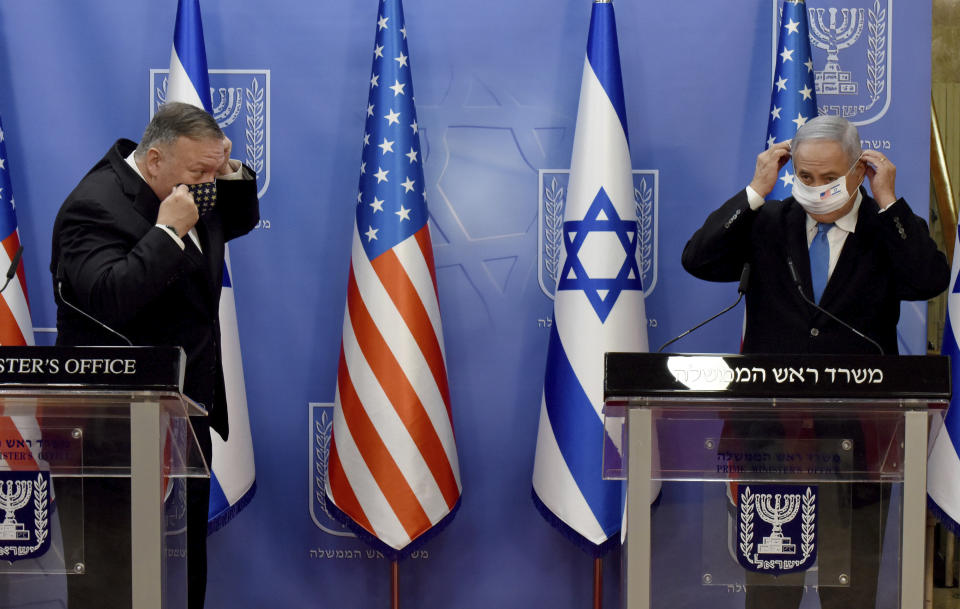 U.S. Secretary of State Mike Pompeo, left, and Israeli Prime Minister Benjamin Netanyahu put on face masks to help prevent the spread of the coronavirus after making joint statements to the press, in Jerusalem, Monday, Aug. 24, 2020. (Debbie Hill/Pool via AP)