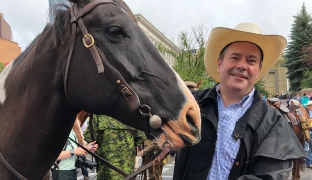 'I believe we're going to have a Calgary Stampede, we're going to have outdoor events,' says Alberta Premier Jason Kenney. He is pictured here with Texas the horse in 2019.  (Geneviève Normand/Radio-Canada - image credit)