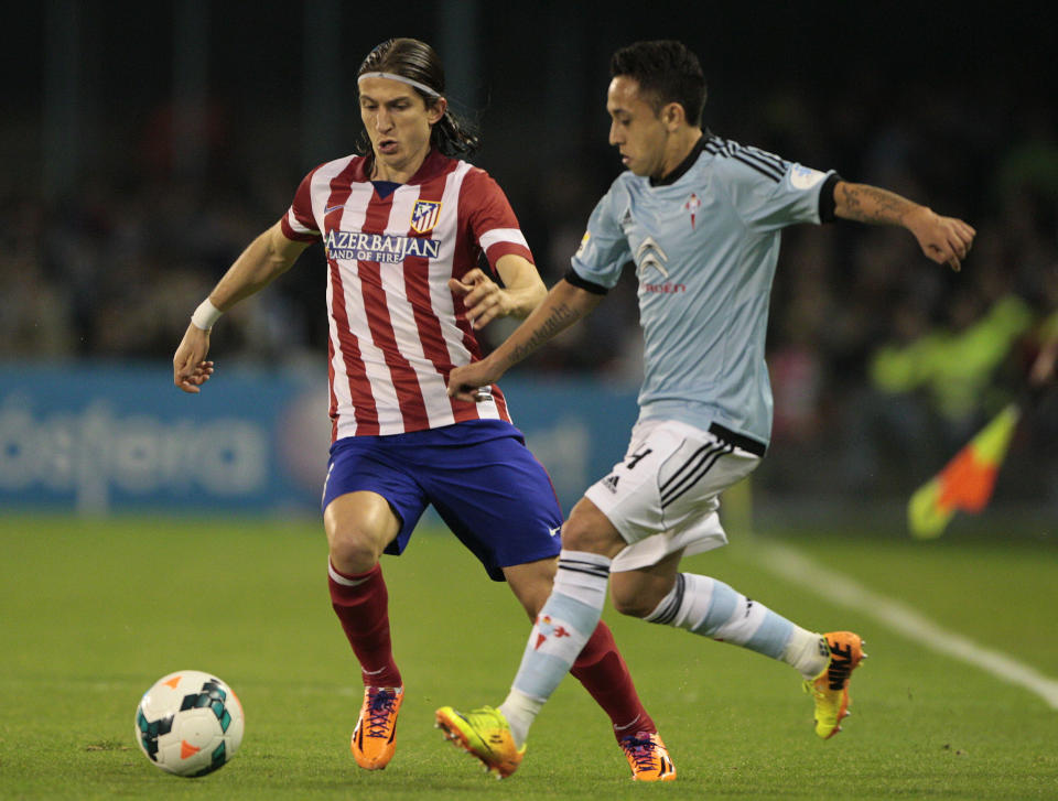 Atletico's Filipe Luis from Brasil, left, in action with Celta's Fabian Orellana from Chile during a Spanish La Liga soccer match at the Balaidos stadium in Vigo, Spain, Saturday, March 8, 2014. (AP Photo/Lalo R. Villar)