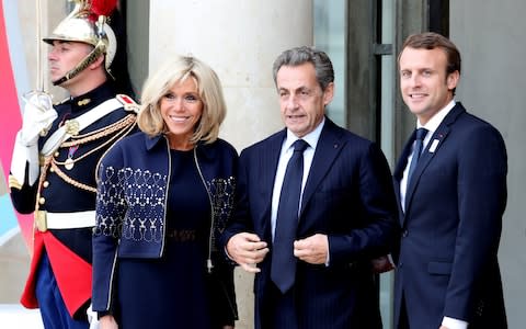 French President Emmanuel Macron (R) and his wife Brigitte (L) welcome former French President Nicolas Sarkozy (C) for Paris 2024 Olympic City reception at Elysee Palace in Paris - Credit: Anadolu Agency