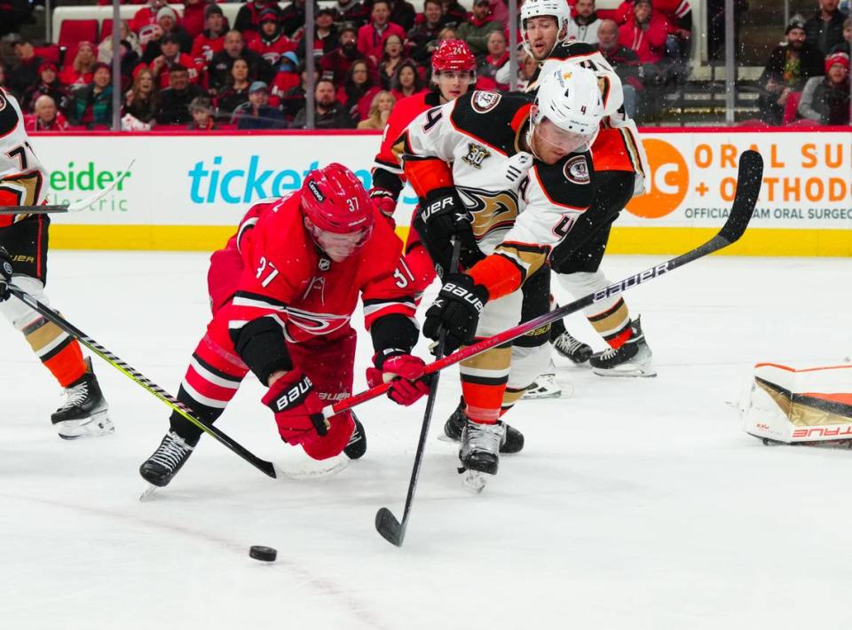 Jan 11, 2024; Raleigh, North Carolina, USA; Anaheim Ducks defenseman Cam Fowler (4) clears the puck away from Carolina Hurricanes right wing Andrei Svechnikov (37) during the first period at PNC Arena. Mandatory Credit: James Guillory-USA TODAY Sports