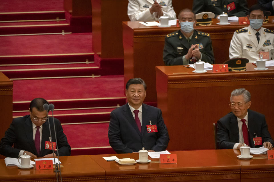 China's President Xi Jinping, center, sits after giving a speech during the opening ceremony of the 20th National Congress of China's ruling Communist Party in Beijing, Sunday, Oct. 16, 2022. The overarching theme emerging from China's ongoing Communist Party congress is one of continuity, not change. The weeklong meeting is expected to reappoint Xi as leader, reaffirm a commitment to his policies for the next five years and possibly elevate his status even further as one of the most powerful leaders in China's modern history. (AP Photo/Mark Schiefelbein)