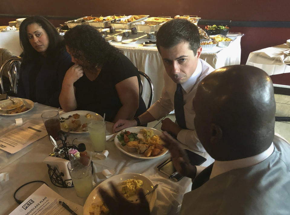 Democratic presidential candidate Pete Buttigieg, third from left, listens to Mikey Kelly as the South Bend mayor meets with black voters at a soul food restaurant in North Las Vegas, Saturday, Dec. 21, 2019. (AP Photo/Michelle L. Price)