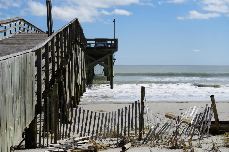 What remains of a pier stands at Pawleys Island, S.C., on Saturday, Oct. 1, 2022. Winds, rain and surf from Hurricane Ian pounded Pawleys on Friday, pushing tons of sand from beach dunes under homes and across the town's handful of roads and breaking apart the pier. (AP Photo/Meg Kinnard)