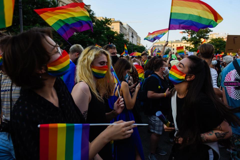 People wear protective face masks with rainbow colors and dance during the 2020 Equality March on Aug. 29, 2020, in Krakow, Poland. Growing hostility toward the LGBTQ community in Poland drew a wave of protests.