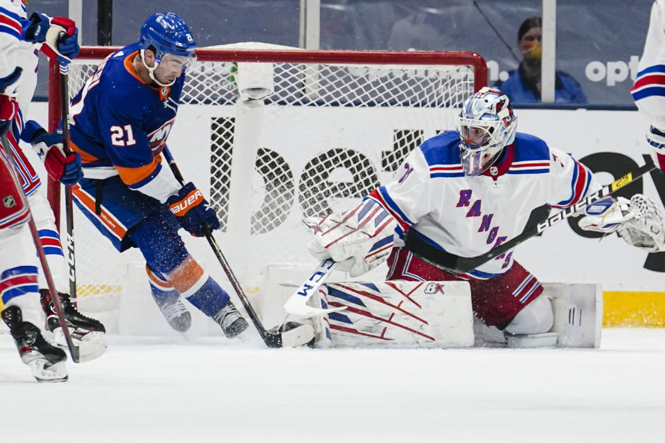 New York Rangers goaltender Igor Shesterkin, right, stops a shot by New York Islanders' Kyle Palmieri (21) during the first period of an NHL hockey game Tuesday, April 20, 2021, in Uniondale, N.Y. (AP Photo/Frank Franklin II)