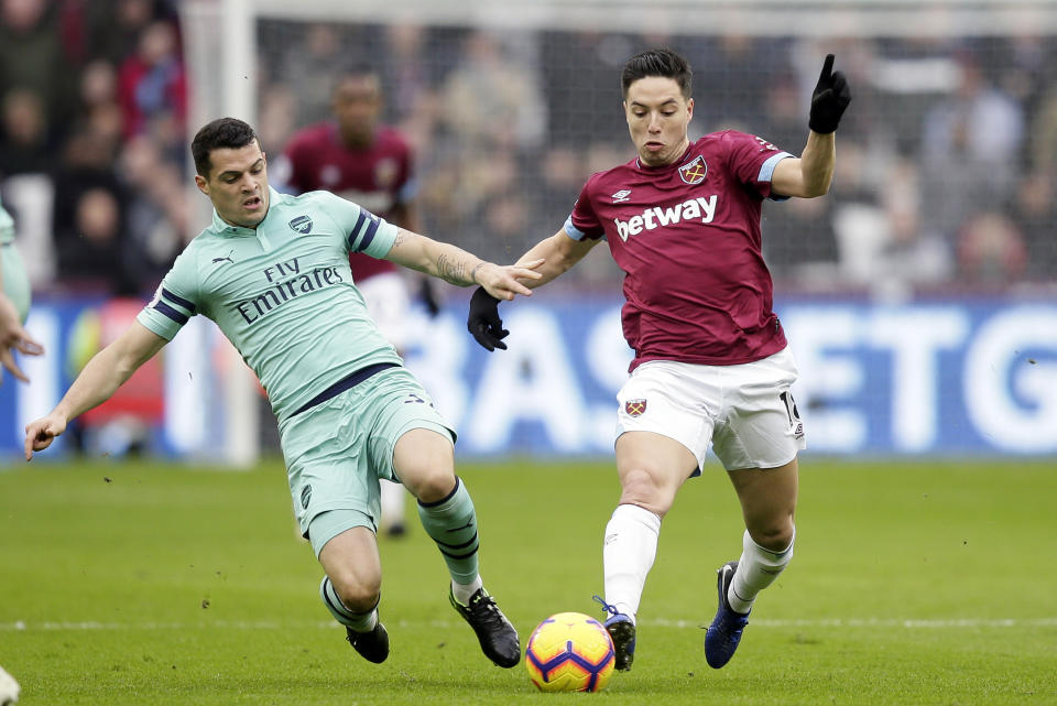 Arsenal's Granit Xhaka tackles West Ham's Samir Nasri, right, during the English Premier League soccer match between West Ham United and Arsenal at London Stadium in London, Saturday, Jan. 12, 2019. (AP Photo/Tim Ireland)