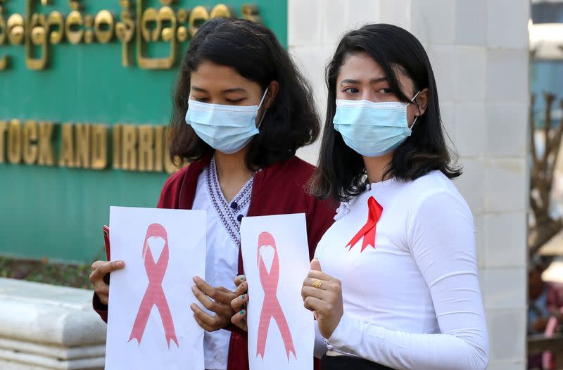 Government staff wearing red ribbons pose during a protest against the coup that ousted elected leader Aung San Suu Kyi in Naypyitaw