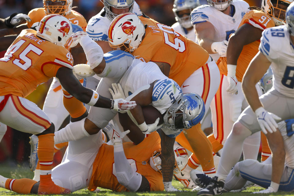 TAMPA, FLORIDA - OCTOBER 15: Devin White #45 of the Tampa Bay Buccaneers, Yaya Diaby #0 of the Tampa Bay Buccaneers, and Vita Vea #50 of the Tampa Bay Buccaneers tackle David Montgomery #5 of the Detroit Lions during the second quarter at Raymond James Stadium on October 15, 2023 in Tampa, Florida. (Photo by Mike Ehrmann/Getty Images)