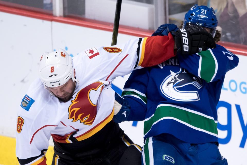 Calgary Flames' Nicklas Grossmann, left, of Sweden, checks Vancouver Canucks' Loui Eriksson, of Sweden, during the second period of an NHL hockey preseason game, Thursday, Oct. 6, 2016, in Vancouver, British Columbia. (Darryl Dyck/The Canadian Press via AP)