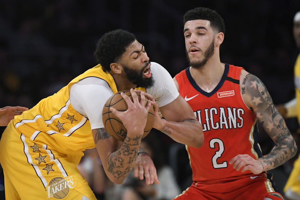 New Orleans Pelicans guard Lonzo Ball, right, tries to get the ball from Los Angeles Lakers forward Anthony Davis during the second half of an NBA basketball game Friday, Jan. 3, 2020, in Los Angeles. The Lakers won 123-113. (AP Photo/Mark J. Terrill)