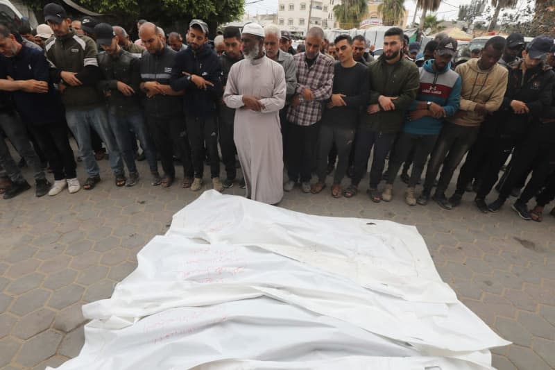 Relatives of the Palestinians killed in Israeli attacks, perform funeral prayer in front of the dead bodies after receiving them from the morgue of Al-Aqsa Hospital. Omar Ashtawy/APA Images via ZUMA Press Wire/dpa