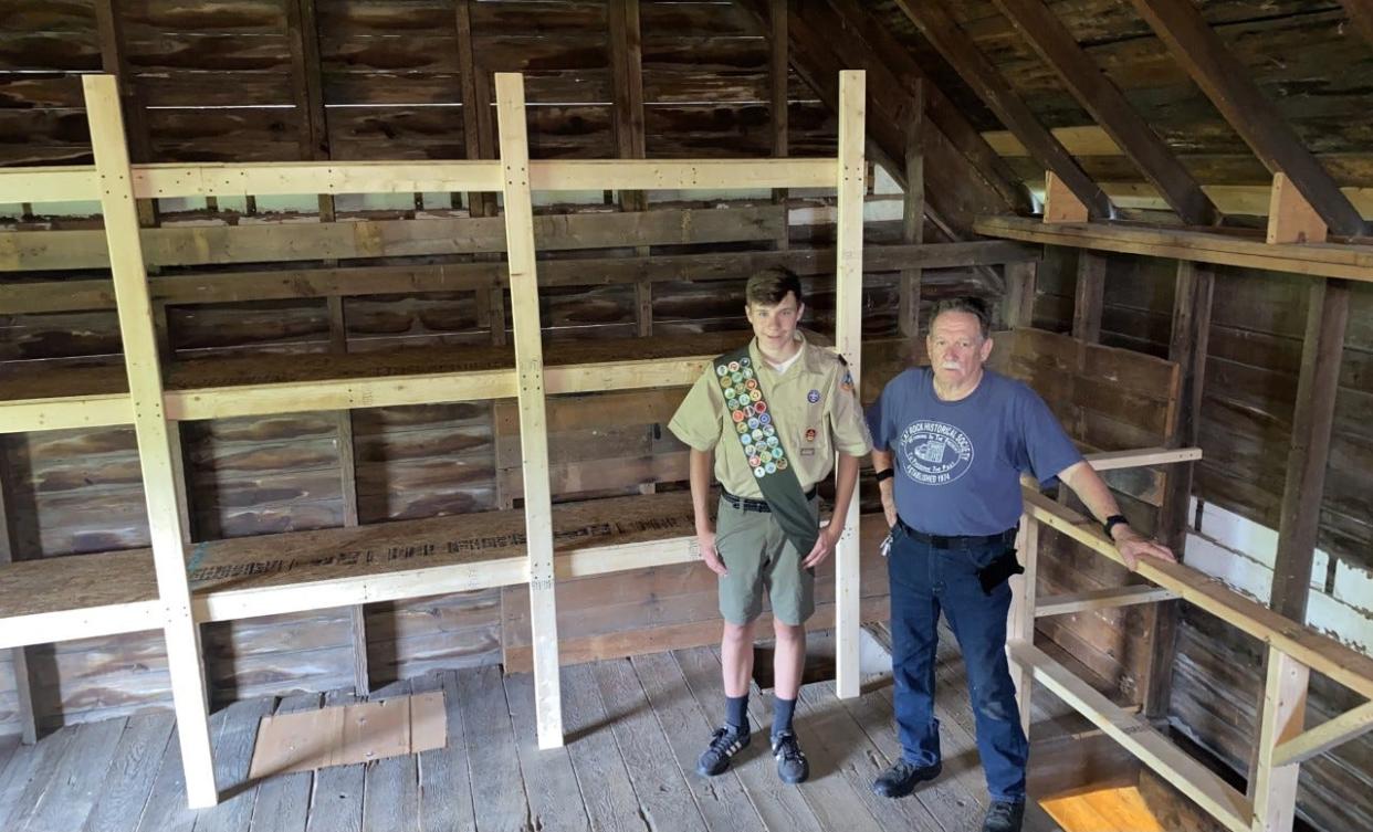 Jacob Marsh (left) stands  by the shelves he built for his Eagle Scout project. Next to him is Bruce Chapin, president of the Flat Rock Historical Society.
Provided by the Flat Rock Historical Society