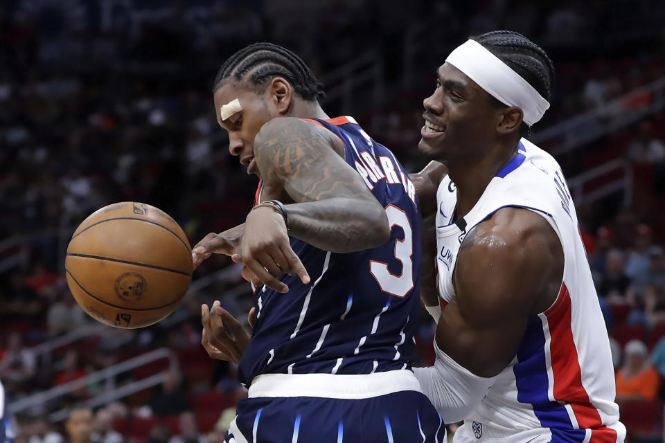 Houston Rockets guard Kevin Porter Jr. (3) and Detroit Pistons center Jalen Duren wrestle for a rebound that resulted in a jump-ball call during the first half of an NBA basketball game Friday, March 31, 2023, in Houston. (AP Photo/Michael Wyke)
