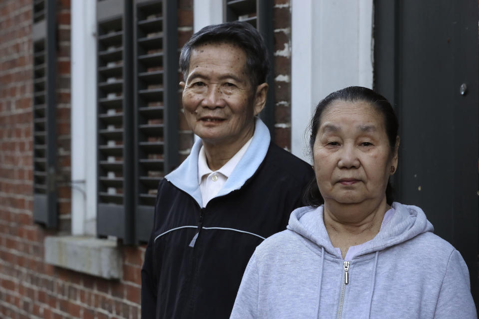 In this Wednesday, May 20, 2020 photo Pay Reh, left, and Poe Meh, right, originally of Burma, also known as Myanmar, stand for a photograph at the entrance to their home, in Lowell, Mass. The elderly couple, who came to Massachusetts as refugees in 2011, were granted a special naturalization oath ceremony in May of 2020 after their lawyer argued that they faced financial hardship if they weren't naturalized immediately. (AP Photo/Steven Senne)