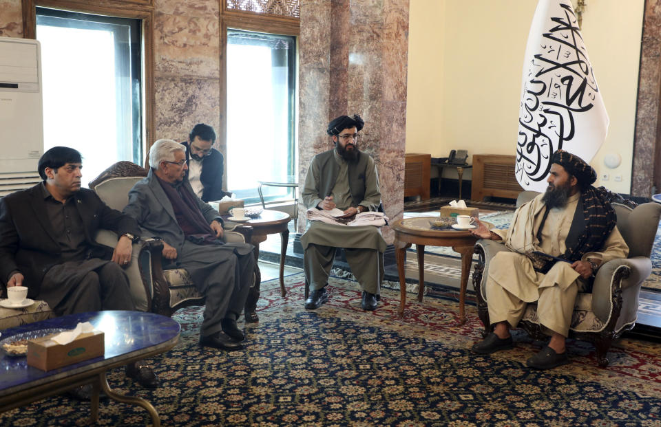 Mullah Abdul Ghani Baradar, the Taliban-appointed deputy prime minister for economic affairs, right, speaks with Pakistan's defense minister, Khawaja Mohammad Asif, during a meeting in Kabul, Afghanistan, Wednesday, Feb. 22, 2023. Pakistan's defense minister was in Afghanistan on Wednesday, meeting with officials there in an effort to resolve this week's closure by the Taliban administration of a key border crossing between the two neighboring countries, officials said. (Deputy Prime Minister Minister Office via AP)