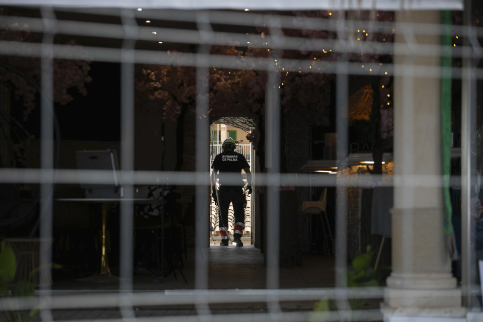 Un bombero recorre el interior de un edificio tras un derrumbe en el que fallecieron cuatro personas, en Palma de Mallorca, España, el 24 de mayo de 2024. (AP Foto/Francisco Ubilla)