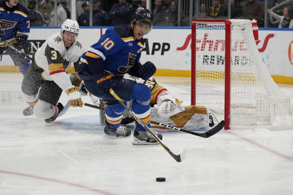 St. Louis Blues' Brayden Schenn (10) and Vegas Golden Knights' Brayden McNabb (3) chase after a loose puck during the second period of an NHL hockey game Sunday, March 12, 2023, in St. Louis. (AP Photo/Jeff Roberson)