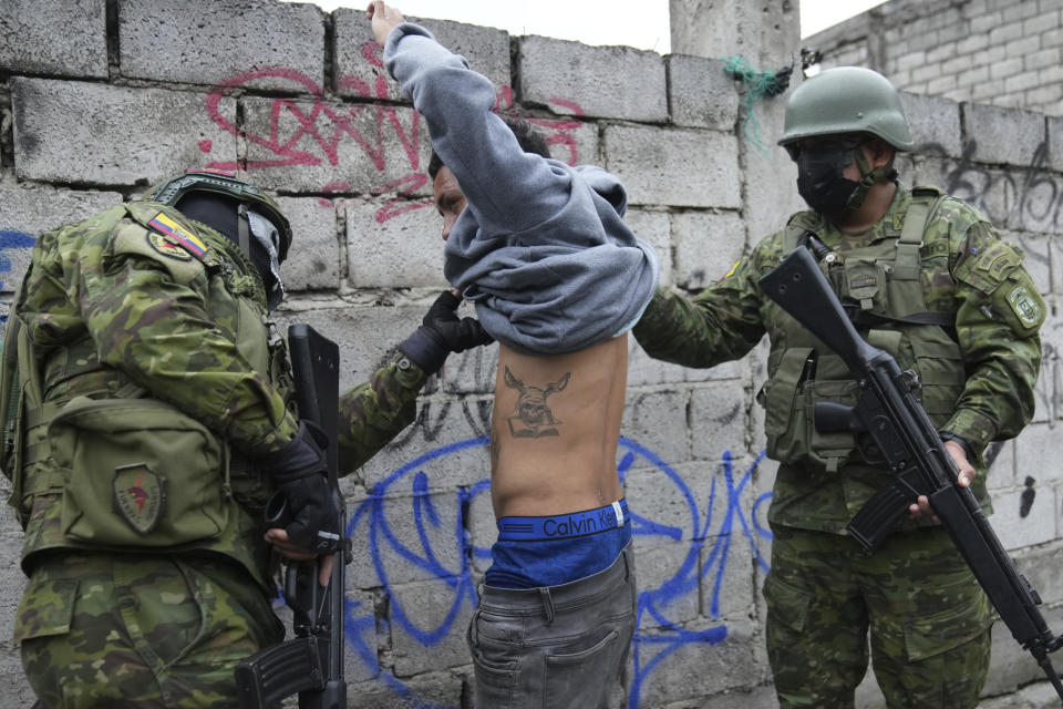 Militares detienen momentáneamente a un joven para revisar si lleva tatuajes relacionados a las pandillas mientras patrullan por el sur de Quito, Ecuador, el viernes 12 de enero de 2024, como secuela a la fuga de dos cabecillas de bandas criminales de prisión. El presidente Daniel Noboa decretó el lunes el estado de emergencia nacional debido a una ola de criminalidad, una medida que permite a las autoridades suspender los derechos de las personas y movilizar a los militares. El gobierno también impuso un toque de queda. (Foto AP/Dolores Ochoa)