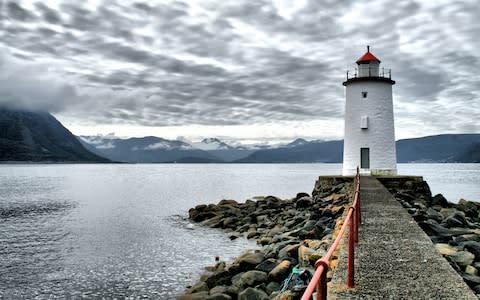 Hogstein lighthouse at the end of a pier on Godoy island - Credit: Getty