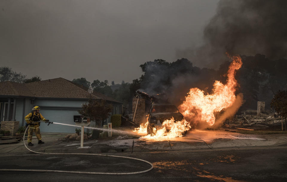 A firefighter puts out a hot spot that flared up in a destroyed neighborhood in Santa Rosa.&nbsp;